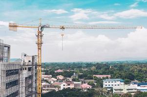 grue à tour dans le chantier de construction de bâtiments élevés avec fond de ciel bleu nuageux photo