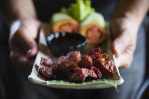 homme servant une recette de porc frit - nourriture célèbre de la tradition locale du nord de la Thaïlande photo