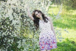 belle fille européenne blanche avec une peau propre dans le parc avec des arbres en fleurs photo