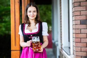 femme russe sexy en robe bavaroise tenant des chopes à bière. photo