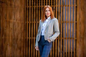 expert en affaires confiant. heureux professionnel réussi posant près d'un immeuble de bureaux. fille européenne. femme d'affaires russe. concept de femme chef d'entreprise. portrait de femme d'affaires prospère photo