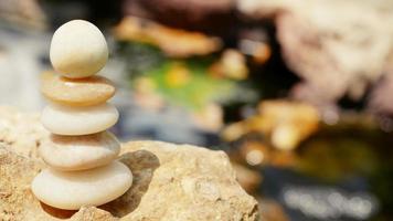 les pierres d'équilibre sont empilées comme des pyramides dans un fond de bokeh naturel doux, représentant le concept philosophique calme du bien-être du jaïnisme. photo