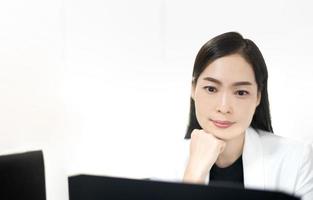 une femme asiatique heureuse et satisfaite se repose au bureau à domicile s'assoit avec un ordinateur portable après le travail terminé, ressentez la paix et détendez-vous. photo