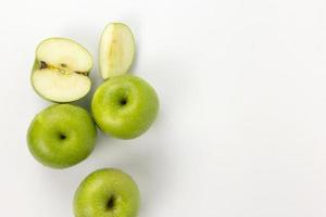 groupes de pommes vertes coupées en demi-tranches isolées sur fond blanc, fruits biologiques pour la santé, un ensemble de pommes en vue de dessus photo