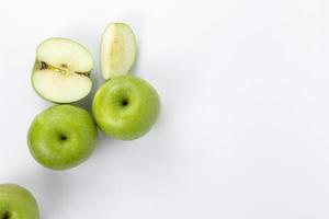 pommes vertes coupées en demi-tranches isolées sur fond blanc, pommes biologiques saines pour la cuisson, conception de concept de fruits biologiques photo