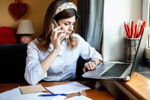 la fille travaille à l'ordinateur dans un café. étudiant apprenant en ligne. blogueur. jeune écrivaine caucasienne tapant sur un ordinateur portable. femme d'affaires attrayante utilisant un ordinateur portable pendant une pause. photo