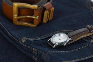 montre-bracelet et ceinture en cuir sur jeans photo