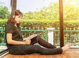 fille écoutant de la musique à partir d'une tablette numérique photo