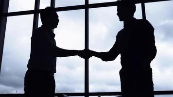 deux hommes d'affaires prospères se serrant la main au bureau. photo
