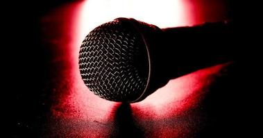 gros plan d'un microphone noir sur fond rouge et noir.