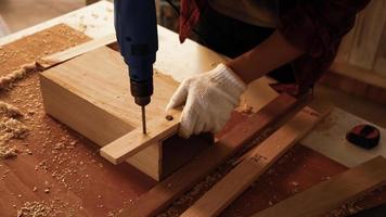 charpentier utilisant une perceuse pour visser des morceaux de planche sur le site. photo
