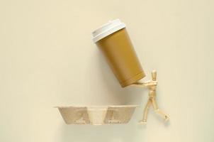 modèle en bois contenant un gobelet à café réutilisable à mettre sur un bac à papier recyclé. concept de la journée mondiale de l'environnement. photo