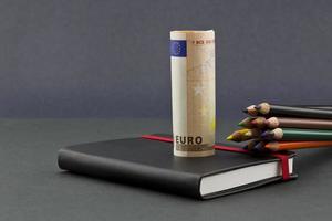 crayons de couleur multiples avec monnaie euro et journal noir photo