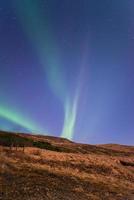 aurores boréales dans la nuit étoilée d'islande, tir vertical. photo