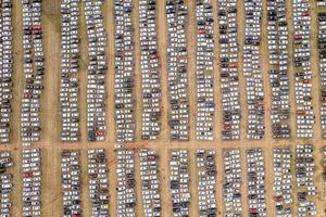 vue aérienne d'un centre de distribution de voitures, voitures garées en rangées sur un terrain prêt à la vente. voitures alignées au port pour l'importation et l'exportation. photo