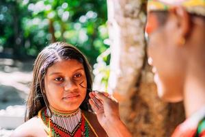 Portrait d'une jeune fille de l'ethnie pataxo indigène faisant du maquillage photo