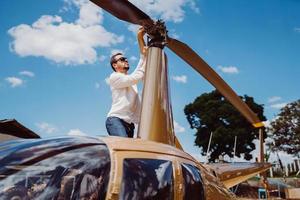 mécanicien masculin ou pilote examinant l'hélicoptère. inspection pré-vol à l'héliport photo