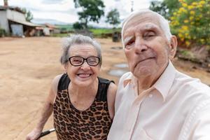 couple d'agriculteurs âgés prenant une photo avec un smartphone.