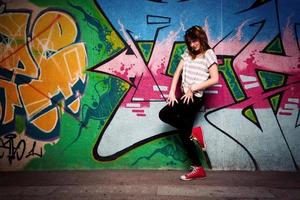 pologne, 2022 - fille élégante dans une pose de danse contre un mur de graffitis photo