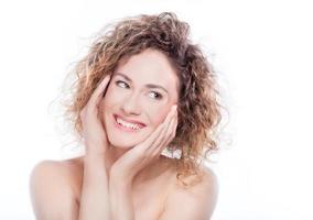 jeune femme souriante aux cheveux bouclés portrait sur blanc photo