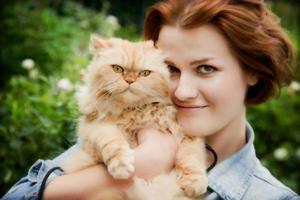 jeune femme avec un chat persan jouant photo