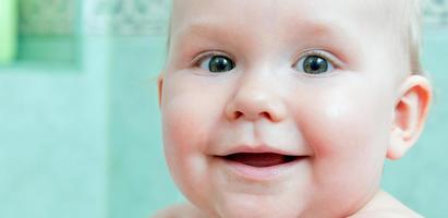 mignon bébé heureux souriant dans une salle de bain photo