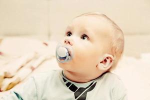 jeune bébé garçon avec un mannequin dans sa bouche portrait photo