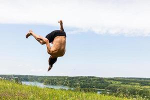 jeune homme sautant sur une colline. photo