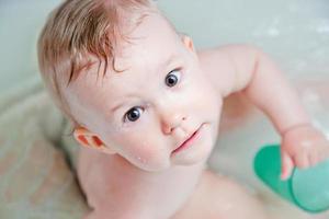 mignon bébé heureux prenant un bain et jouant photo