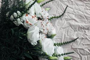 bouquet de fleurs blanches sur fond blanc, sur fond de linge de lit, un bouquet de couleur verte, arrière-plan, belles fleurs blanches photo