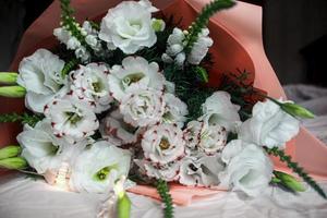 bouquet blanc festif de fleurs sur fond sombre, guirlande, bouquet de couleur rose photo