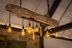 ampoules à incandescence décoratives avec du bois et sur fond de mur de briques photo