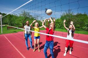 les adolescents jouent pendant un match de volley-ball sur le terrain de jeu photo