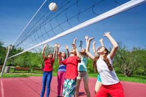 groupe d'adolescents avec les bras levés jouer au volleyball