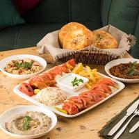 une table à manger pleine de plats délicieux et une corbeille de pain photo