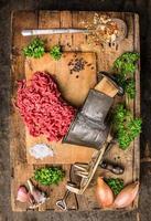 viande hachée de hachoir à viande vintage sur table en bois avec des herbes