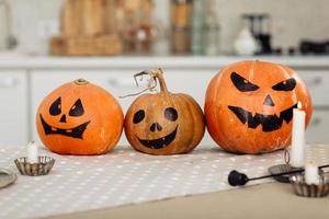 lanterne jack à tête de citrouille d'halloween avec des bougies allumées. citrouilles d'halloween illuminées avec des bougies dans la cuisine. photo