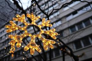 décoration de noël accrochée devant un immeuble résidentiel. gros plan de flocon de neige de lumière led festive prise à berlin, en allemagne. photo