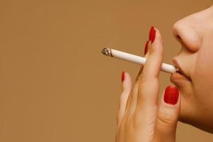 femme fumant la cigarette sur fond orange