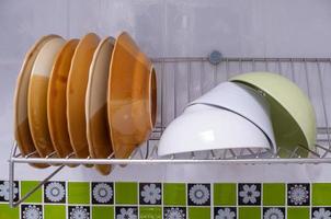 gros plan de la vaisselle nettoyée et du coup sèchent sur l'égouttoir à vaisselle en acier inoxydable. photo