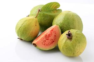 fruit de goyave, rose, frais, biologique, avec feuilles, entier et tranché, isolé sur fond blanc. photo