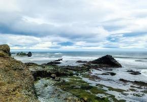 une plage rocheuse avec des bergs sur l'islande dans des vents forts avec des vagues puissantes. photo