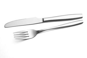 la fourchette et le couteau en métal brillant sur fond blanc. photo