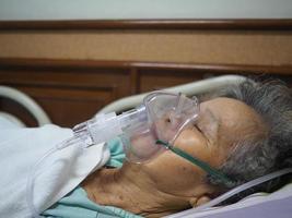 une femme âgée souffre d'asthme et a besoin d'une nébulisation, d'une thérapie par inhalation par le masque de l'inhalateur photo
