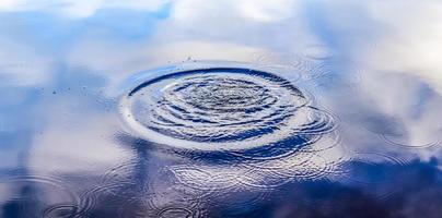 belle eau dans un lac avec des éclaboussures d'eau et des ondulations à la surface avec des nuages et des reflets de ciel bleu photo