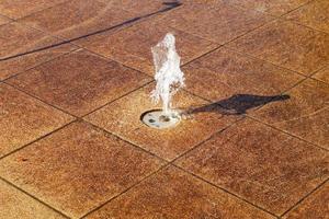 surface d'eau en mouvement reflétant la lumière du soleil dans une fontaine trouvée en allemagne. photo