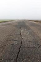 route asphaltée, gros plan d'automne et de brouillard. faible profondeur de champ. au fond on voit le ciel photo