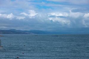 paysage de montagne flou spectaculaire sur la plage de la mer noire, paysage avec nuages et ciel, reflété dans l'eau. photo