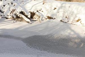 une petite rivière dont l'eau est gelée en hiver photo