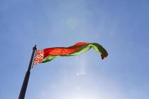 drapeau d'état biélorusse sur un ciel bleu photo